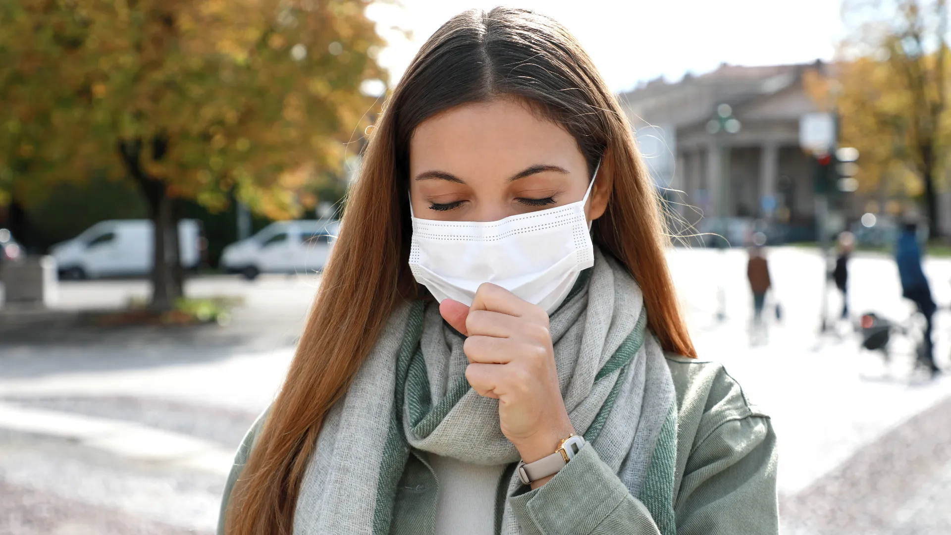 Women with mask outdoors coughing